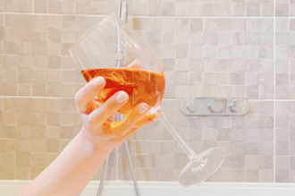 Woman in bath with wine glass relaxing